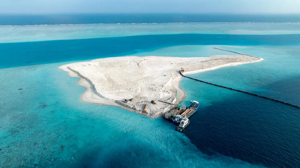 Aerial view of a contractor's base camp on reclaimed sand at Ras Malé, with site offices, containers and rows of construction machinery