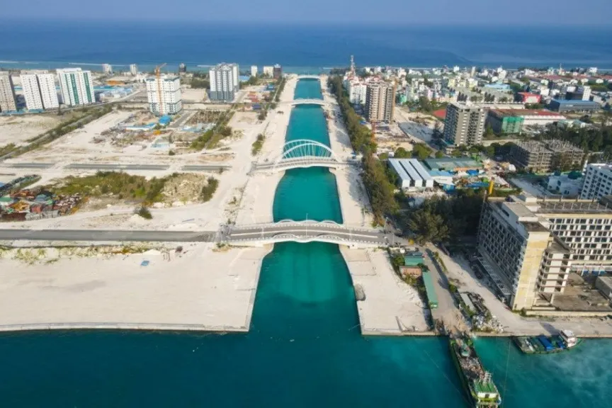 Aerial view of Hulhumalé Phase 2, with a turquoise canal crossed by two arched bridges between new apartment blocks and open reclaimed land